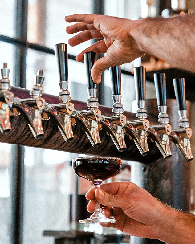 A drink is filled from a row of taps.