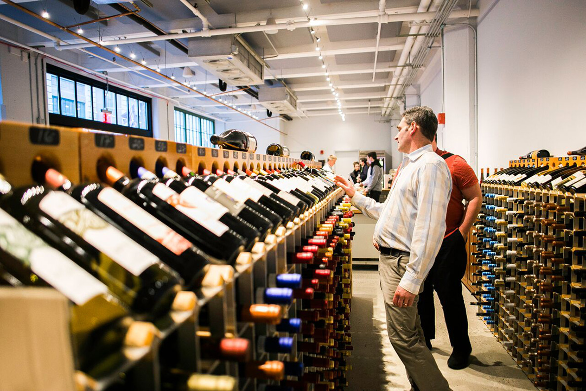 People browse an aisle of wine bottles.