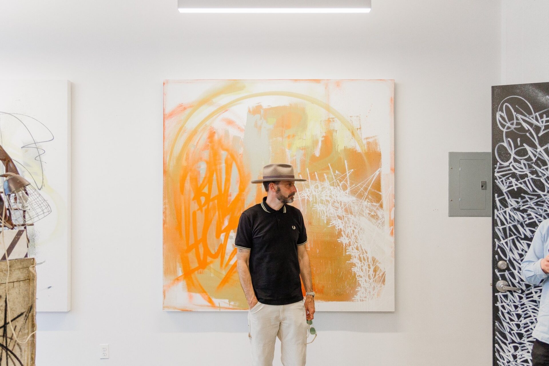 Someone is standing in front of an orange painting.