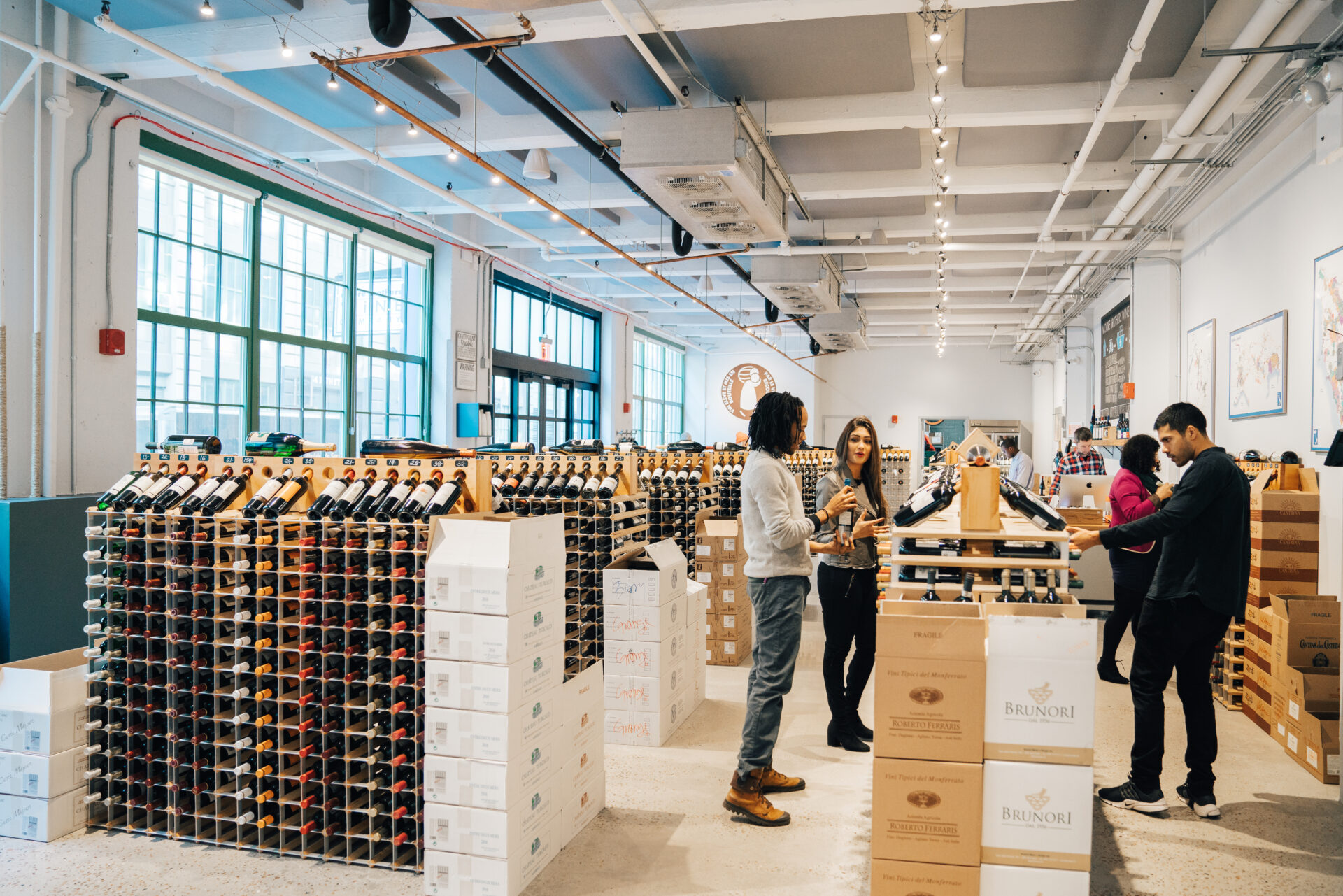 People are shopping for wine in a wine store.