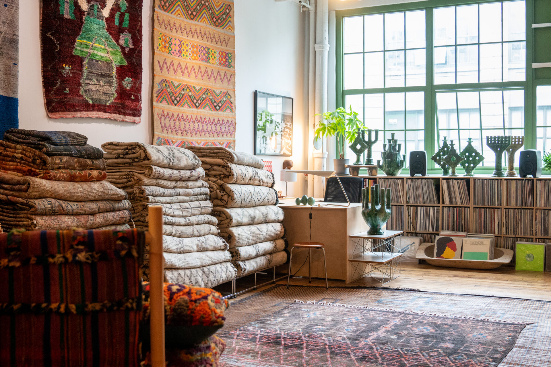 The interior of a store with many rugs lined up on the wall.