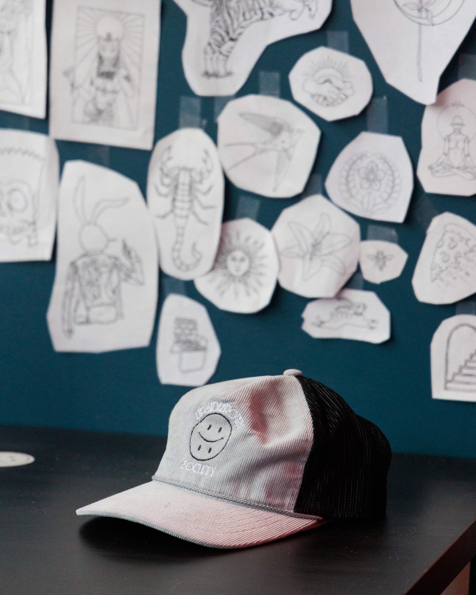 An image of a hat on a table with pictures i the background.