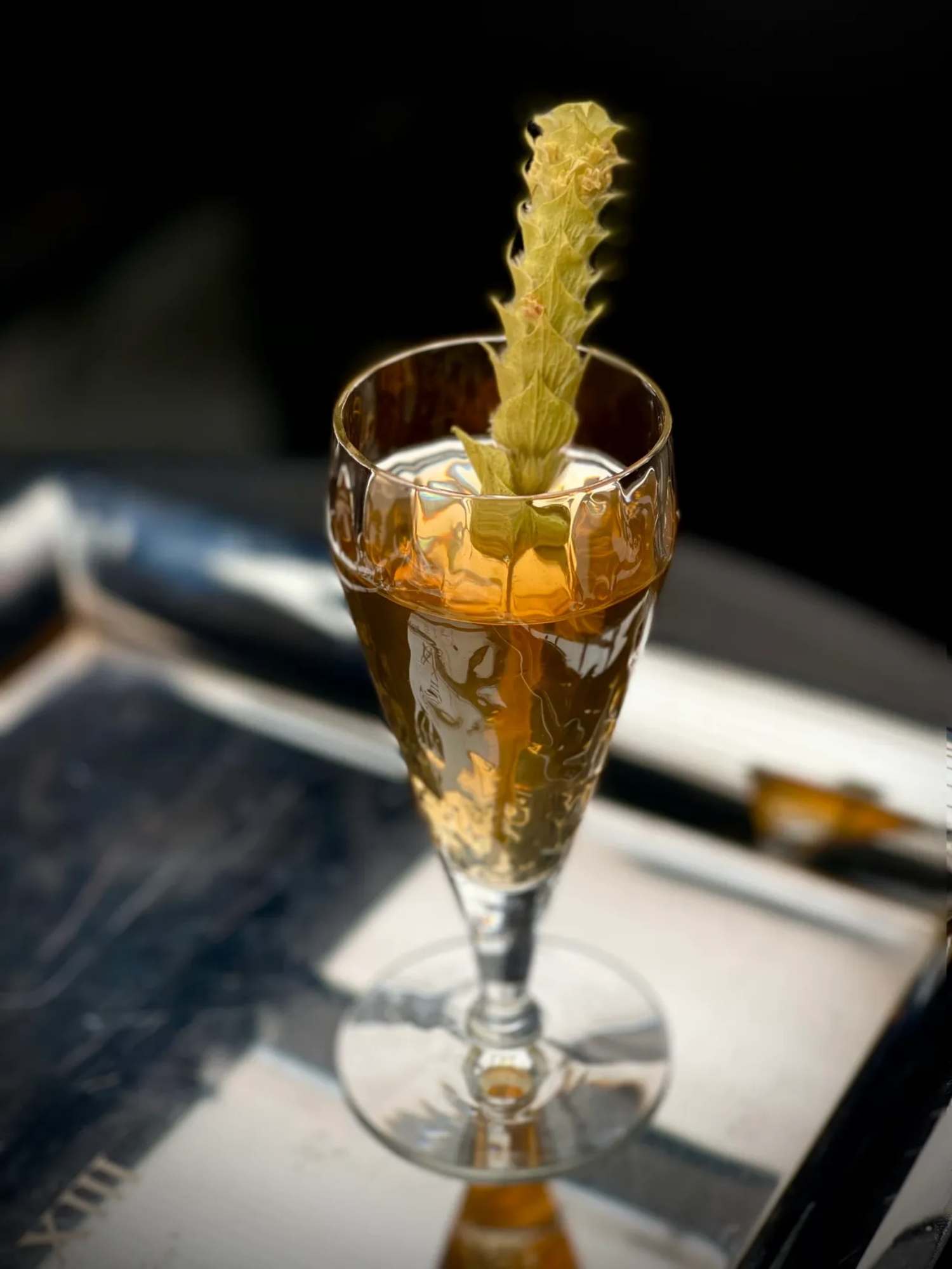 There is a cocktail in a glass on a bar.