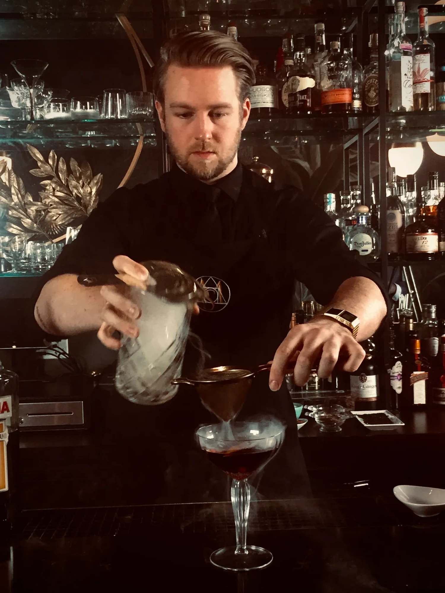 A bartender is pouring a drink.