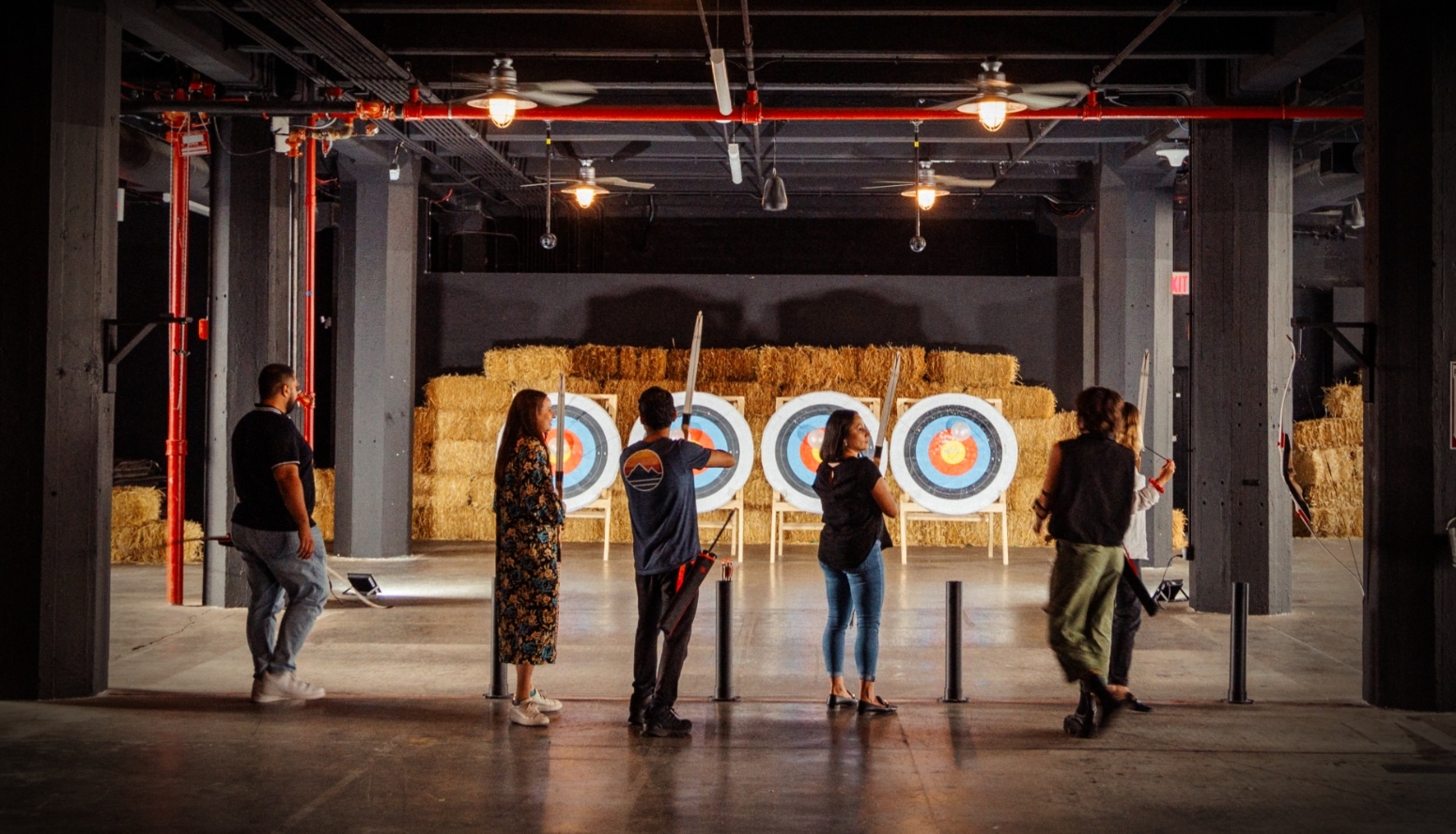 People are doing archery in an event space.