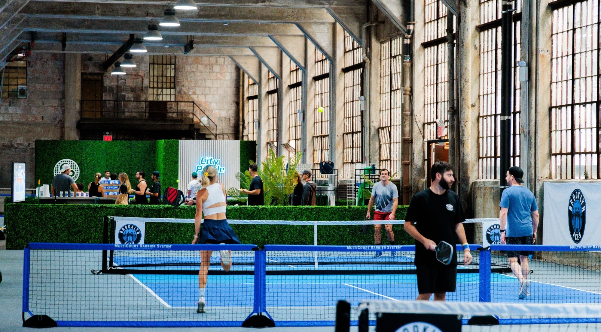 The interior of an event space. People are playing pickleball.