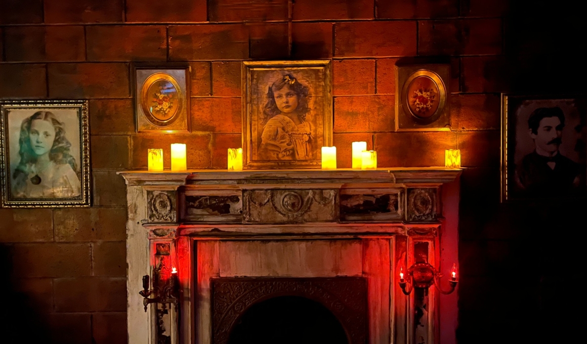 There is a fireplace with portraits above.