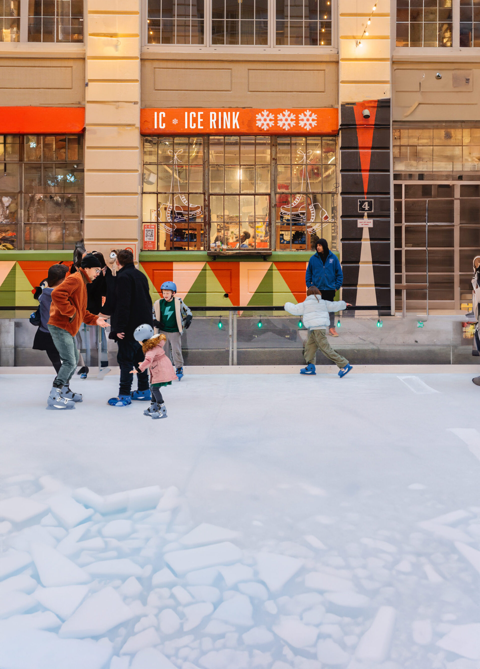 People are ice skating on an ice skating rink.