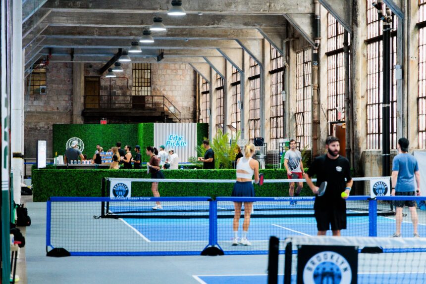 People are playing pickleball at an indoor court.