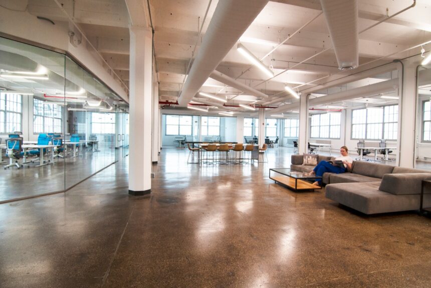 The interior of an office space with someone sitting on a couch.