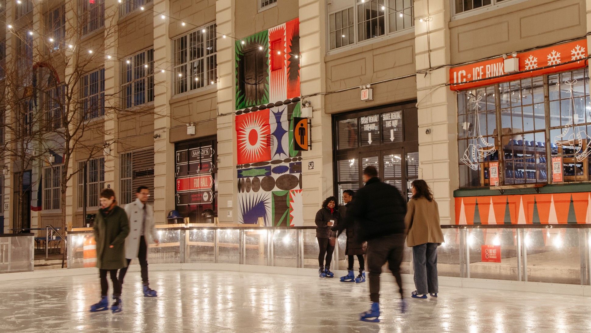 People ice skate outside at night.