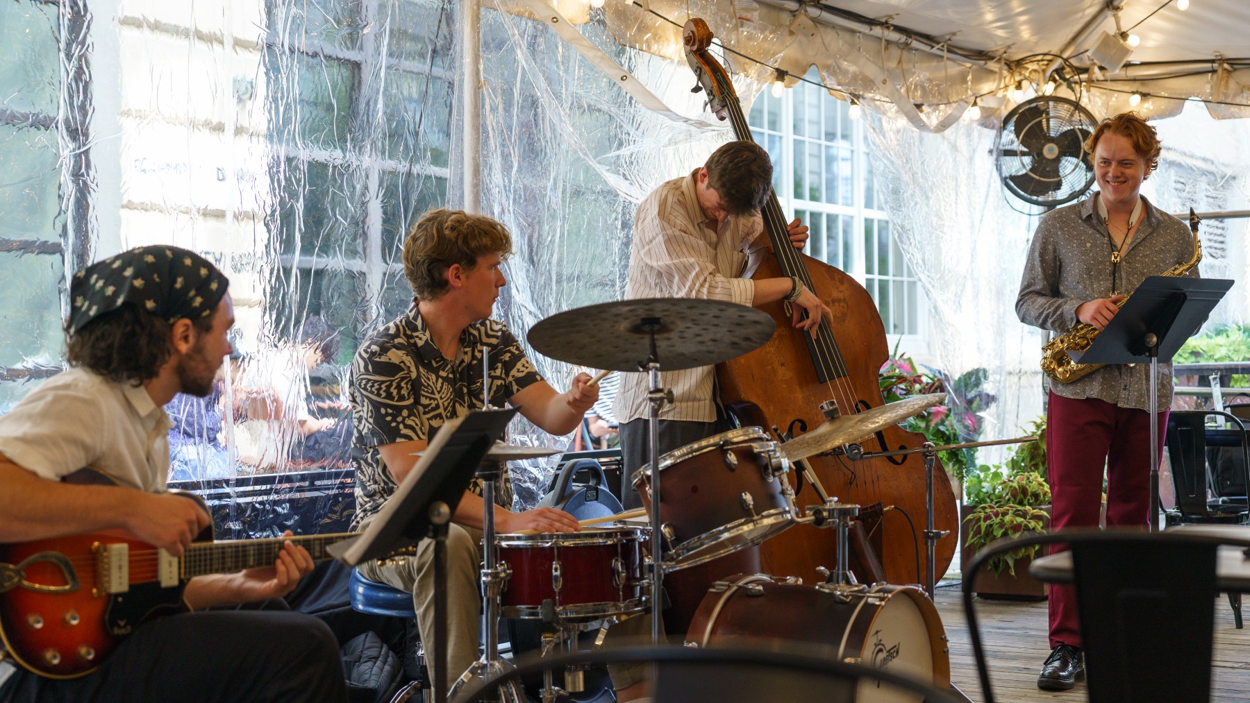 A band plays in an outdoor tent.