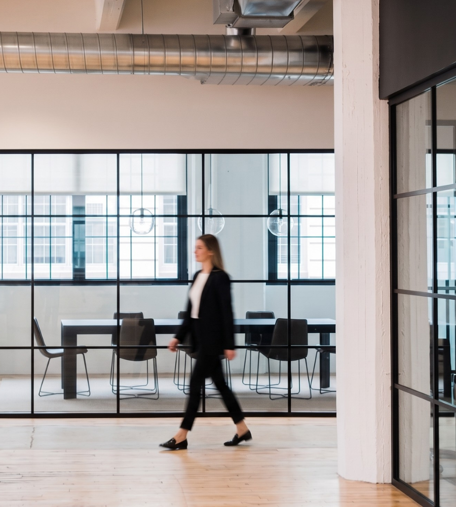Interior view of a modern enterprise office space at Industry City with a woman crossing the room.