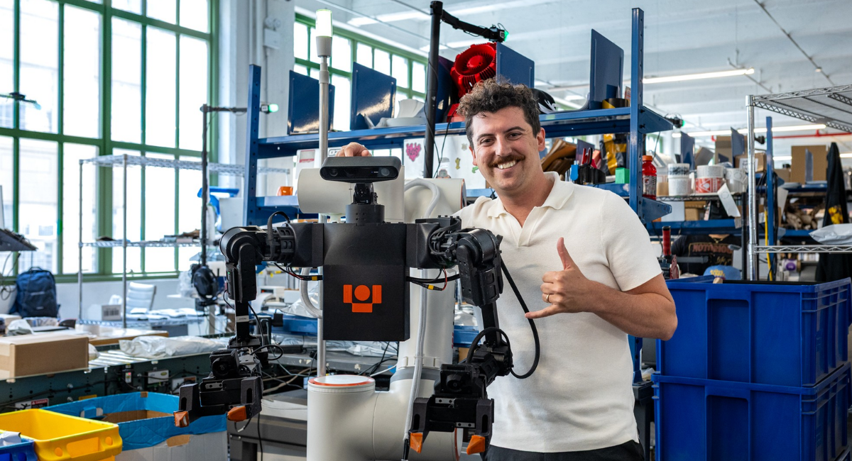 Richard Hurley, CEO of Highline Commerce, stands with a humanoid robot from Ultra Robotics at Industry City